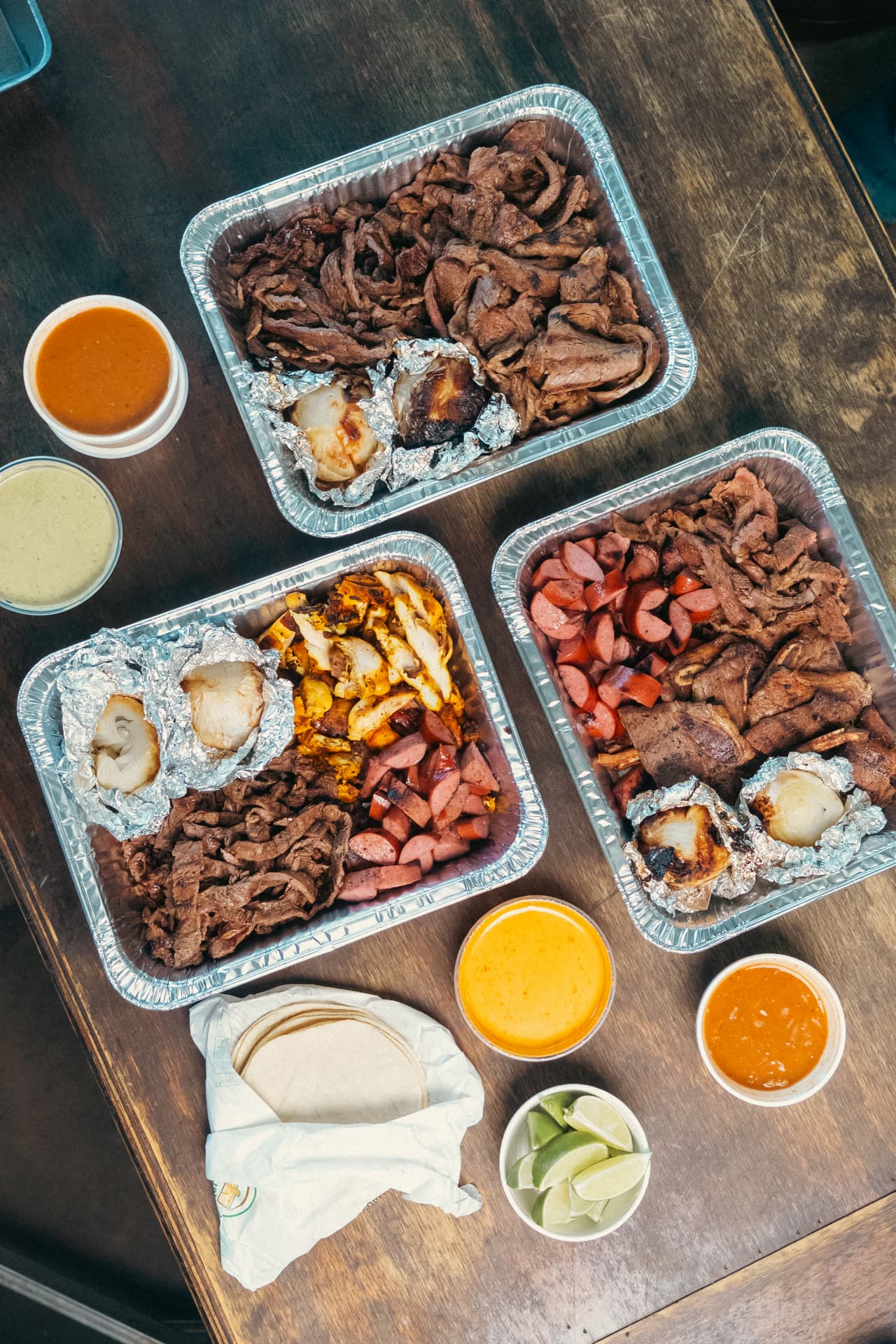 Charolas de catering con fajita, pollo, salchicha, tortillas y salsas de La Ganadera